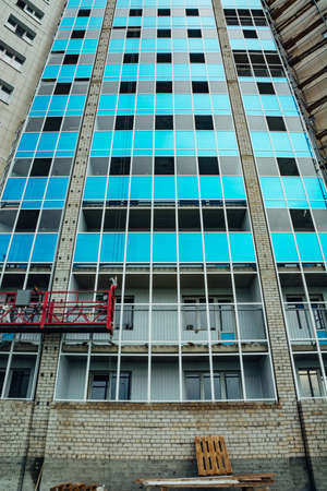 Construction of a modern multi-storey residential building. Glass balconies are blue.の写真素材