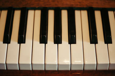 Old Piano keys in artistic processing. Musical instrument. View from above.