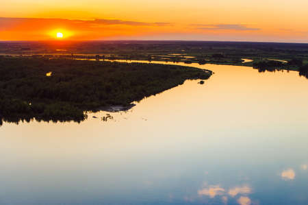 Mirror surface of water at sunset. Altai region. Islands on the river.の写真素材