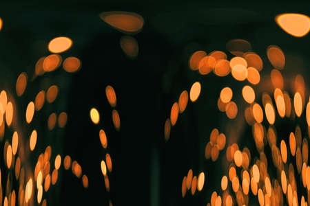 Orange swirling lights on a black background.の写真素材