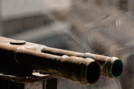 Copper pipes on a glass background with reflection.