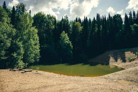 A place for camping on a green lake, surrounded by forest.の写真素材