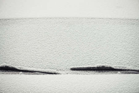 A minimalistic background image of the car's windshield covered with a layer of snow.の写真素材
