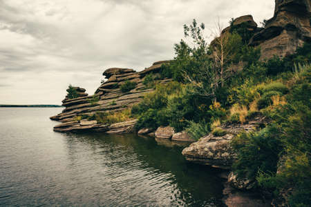 Rocky shore on lake in cloudy weather. Stones of unusual shape.の写真素材