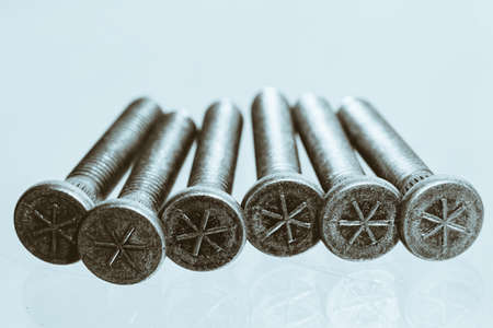 Artwork from gray automotive bolts on blue background close up.の写真素材