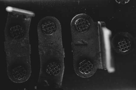 Monochrome background image of obsolete contact panel close-up. Rusty electrical contacts on switchboard is off from voltage.の写真素材