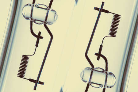 Detail image of filament from dipped beam bulb close-up with copy space on yellow background.の写真素材