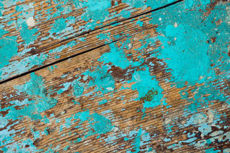 Background image of wooden surface with peeling paint. Old colorful wooden boat close-up. Picturesque texture of vessel fuselage with cracked.の写真素材