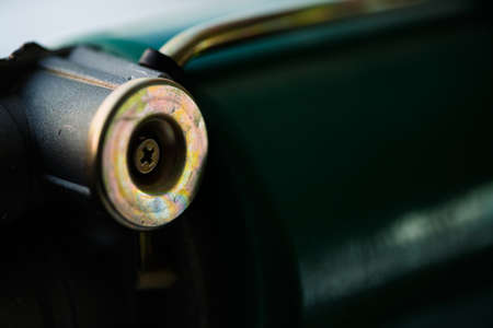 Background image of green auto part close-up. Green metallic surface and gold circle.