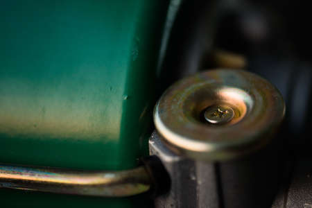Background image of green auto part close-up. Green metallic surface and gold circle.