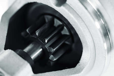 Background image of auto parts with rotor close-up. Big black pinion in metal part. Gear parts...