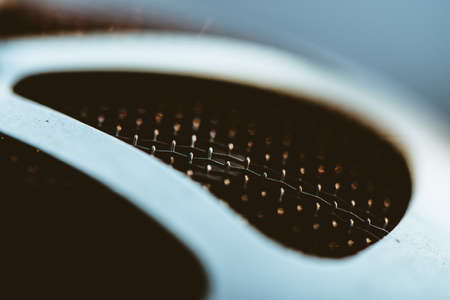 Auto part with shiny mesh. Metallic texture of grid close-up. Triangular shape of grid with gold reflex.の写真素材