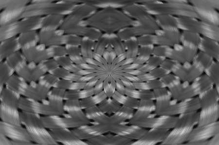 Symmetrical silver metallic wicker texture close-up. Detail background of volume steel surface. Abstract gray braided wire in macro. Surreal shape with copy space. Unusual black and white space.の写真素材