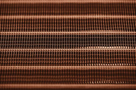 Detailed texture of engine water cooling radiator with horizontal lines. Background image of orange automobile part with copy space close up.の写真素材