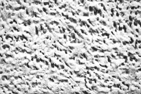 Detailed imperfect white texture of aerated foam block with holes close-up. Side of building is painted whitish. Background of construction from foamed material in macro. Decorative facing of house.の写真素材