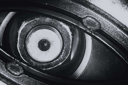 Unusual robotic eye in steampunk style in grayscale. Focused robot look. Monochrome background pattern close-up.の写真素材