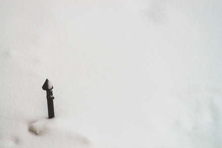 Pipe on white snow close up. Textured winter background. Snow covered cellar with copy space. Abstract minimalist snowy weather texture. Snowdrift. Ventilation of bunker. Storm warning.の写真素材