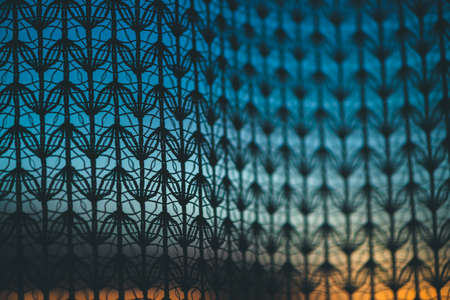 Wonderful vivid dawn from window through patterned curtain. Amazing warm sky behind silhouettes of tulle texture. Orange sunlight. Cosiness textured colorful background with sunrise. Copy space.の写真素材