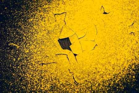 Rough dark black wall with yellow sprays of dye. Colorful background closeup. Dark black texture of concrete wall surface with yellow spots of paint. Painted backdrop. Exfoliated paint. Flaking stuccoの写真素材