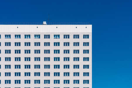 Geometric background with lots of window rows. Modern building texture. Office construction. Apartment building close-up. Many windows on huge wall. European classic high-rise building with copy spaceのeditorial素材