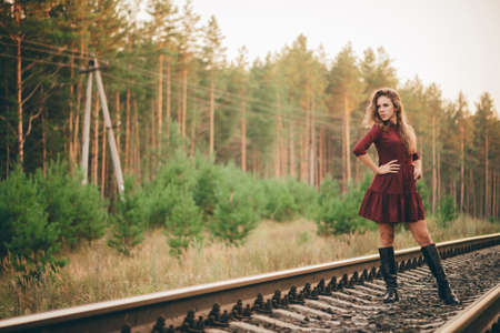 Beautiful dreamy girl with curly natural hair enjoy nature in forest on railway. Dreamer lady in...