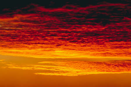 Fiery red blood vampire dawn. Amazing warm dramatic fire cloudy sky. Vivid orange sunlight....