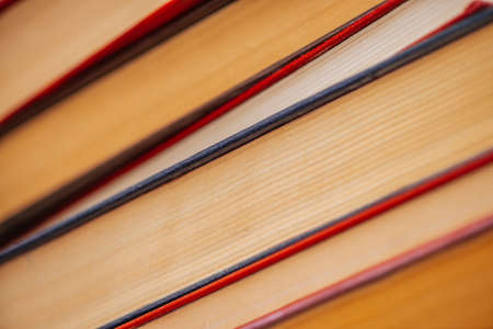 Vintage books close-up. Stack of used old literature in school library. Background from old chaotic reading matter. Dusty faded books diagonally with copy space. Old book store.の写真素材
