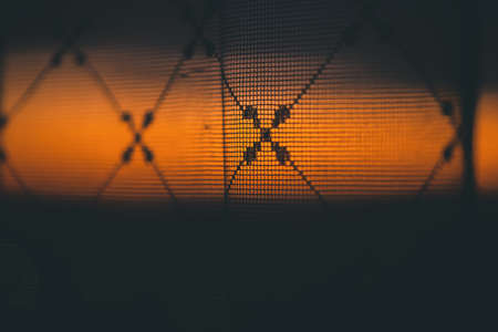 Amazing romantic vivid sunset in window behind silhouettes of tulle texture. Wonderful warm orange...