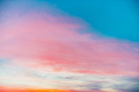 Sunset sky with pink orange light clouds. Colorful smooth blue sky gradient. Natural background of...
