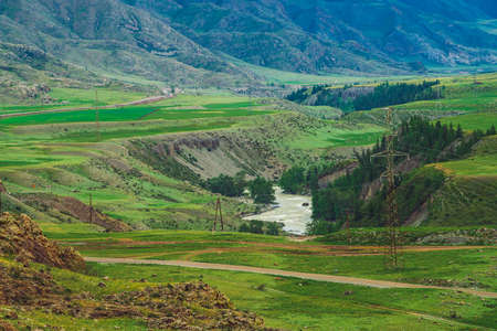 Wonderful mountains with forest cover and mountain river. Power lines in highlands. Electricity in...