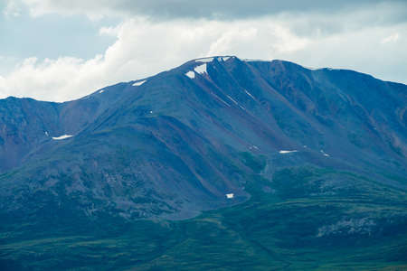 Amazing giant mountain with snow on top in mist in overcast weather. Huge snowy mountain in haze...