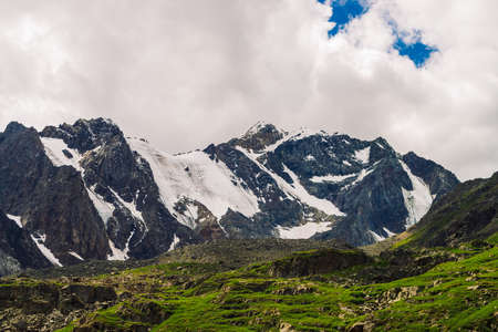Picturesque landscape with amazing huge glacier. Wonderful snowy mountains under blue cloudy sky in...