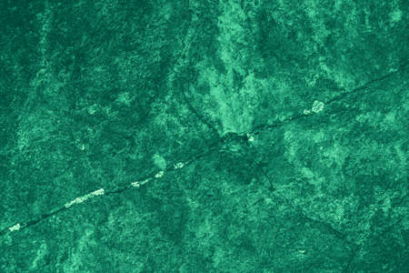 Vintage green background. Rough painted wall of emerald color. Imperfect plane of virid colored. Uneven old decorative toned backdrop of green tint. Texture of emerald hue. Ornamental stony surface.の写真素材