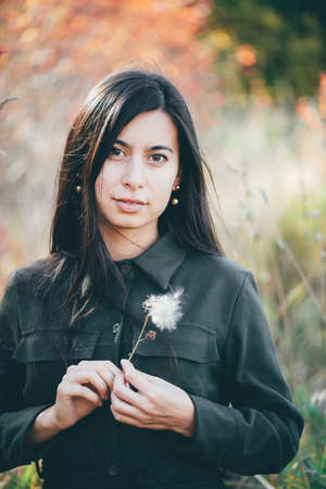 Female beauty portrait surrounded by vivid foliage. Dreamy beautiful girl with long natural black...