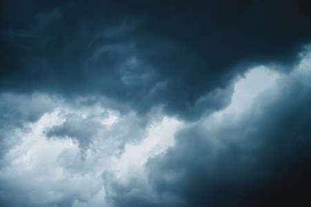 Dramatic cloudscape texture. Dark heavy thunderstorm clouds before rain. Overcast rainy bad weather. Storm warning. Natural blue background of cumulonimbus. Nature backdrop of stormy cloudy sky.の写真素材