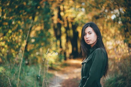 Female beauty portrait surrounded by vivid foliage. Dreamy beautiful girl with long natural black...
