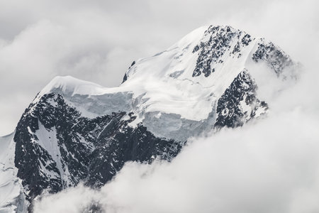 Atmospheric minimalist alpine landscape with massive hanging glacier on snowy mountain peak. Big...