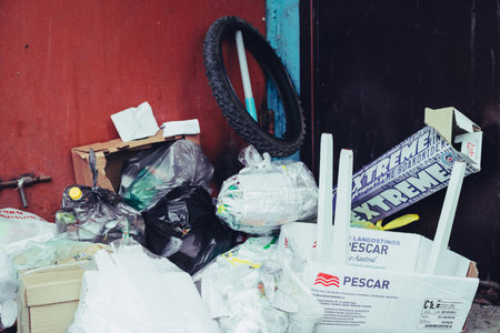 Garbage piled near entrance to urban apartment building. Trash heap blocked garbage chute. Bunch of...