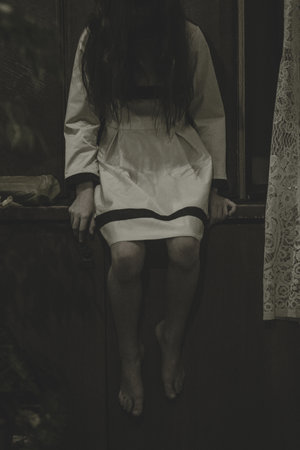 Demon possessed little girl at night. Mad scary girl at dark night. Horror background with child...