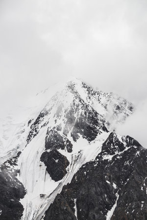 Atmospheric minimalist alpine landscape with massive hanging glacier on snowy mountain peak. Big...