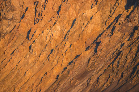 Sunny nature background of rockies in sunlight. Vivid natural mountain texture of big rough rocks....