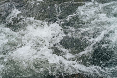 Full frame nature background of water riffle of mountain river. Powerful water stream of mountain...