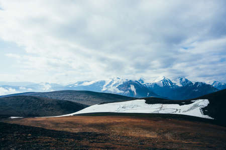 Atmospheric alpine landscape to rocky mountain with glacier. Snowy rockies in highland valley and...
