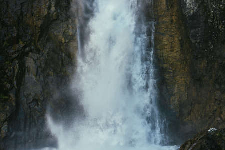 Atmospheric minimal landscape with vertical big waterfall on rock mountain wall. Powerful large...