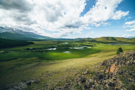 Beautiful green mountain scenery with lake system on tableland among forest hills. Scenic landscape with lakes group on plateau. Blue lakes system and channels in wide valley. System of mountain lakesの写真素材
