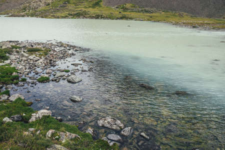 View from top to turquoise mountain lake with transparent water. Atmospheric mountain landscape with...