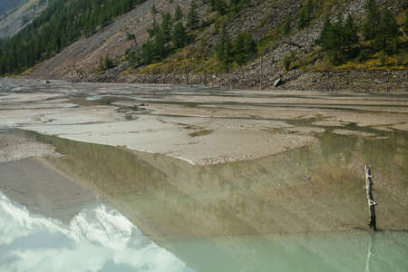 Scenic alpine landscape with beautiful shallow mirror mountain lake with reflection of snowy...