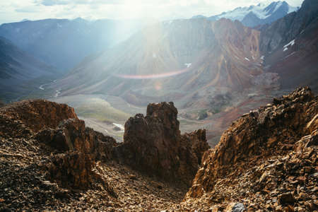 Excellent view from big pointy rocks to motley mountain valley in sunlight. Scenic mountain landscape with multicolor pointed rocks in golden sunlight. Sunny highland scenery with golden sharp rocks.の写真素材