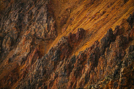 Scenic nature background of multicolor mountain. Colorful nature backdrop of motley rocks. Multicolor great rocks of vivid colors. Beautiful red orange rufous golden rocks. Closeup of motley mountain.の写真素材