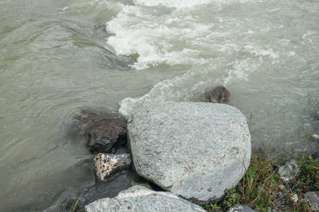 Minimalist mountain scenery with rapids of fast turbulent river. Beautiful mountain landscape with powerful mountain creek with stones and boulders. Minimal scenic nature background of mountain river.の写真素材